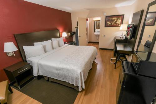 a hotel room with a bed and a television at Red Roof Inn PLUS+ Chicago - Willowbrook in Willowbrook