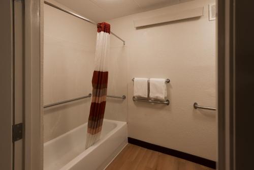 a bathroom with a tub and a shower with a shower curtain at Red Roof Inn PLUS+ Chicago - Willowbrook in Willowbrook