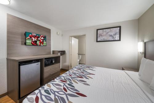 a hotel room with a bed and a tv at Red Roof Inn San Antonio E - Frost Bank Center in San Antonio