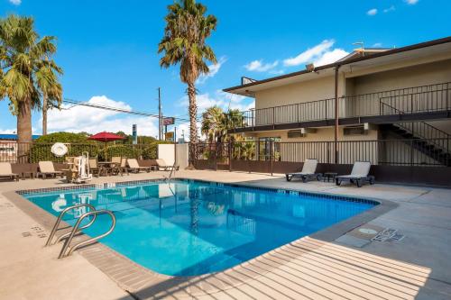 a swimming pool in front of a building with palm trees at Red Roof Inn San Antonio E - Frost Bank Center in San Antonio