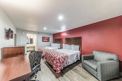 a hotel room with a bed and a table and a chair at Red Roof Inn Dallas - Mesquite Fair Park NE in Mesquite