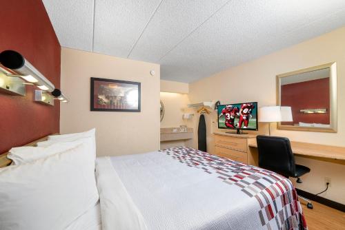 a hotel room with a bed and a desk at Red Roof Inn Detroit - Dearborn-Greenfield Village in Dearborn
