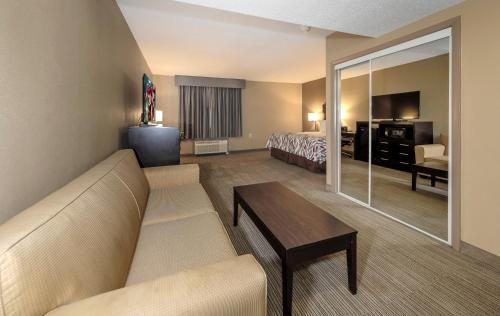 a hotel room with a couch and a bed at Red Roof Inn & Suites Newburgh - Stewart Airport West Point in New Windsor