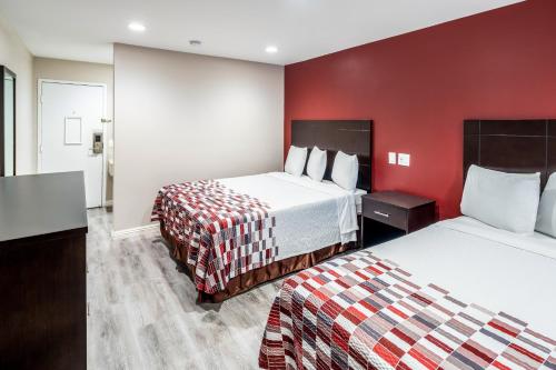 Cette chambre comprend 2 lits et un mur rouge. dans l'établissement Red Roof Inn St George, UT - Convention Center, à Saint George