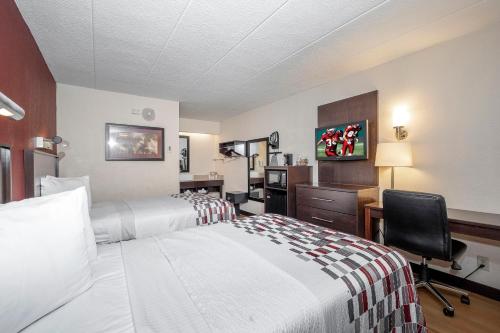 a hotel room with two beds and a desk and a chair at Red Roof Inn Mt Laurel in Mount Laurel