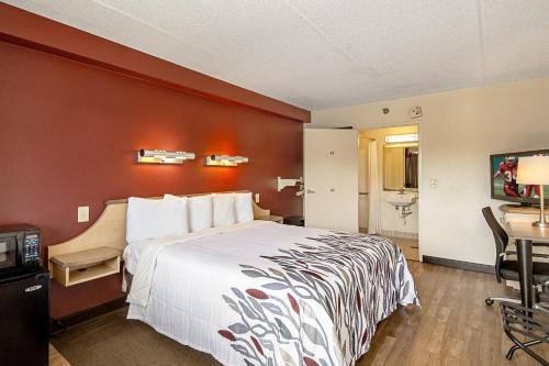 a hotel room with a large bed and a desk at Red Roof Inn St Clairsville - Wheeling West in Saint Clairsville