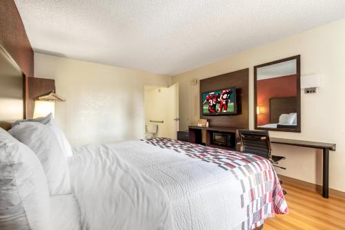 a hotel room with a white bed and a mirror at Red Roof Inn Phoenix- Midtown in Phoenix