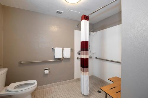 a bathroom with a toilet and a red and white shower at Red Roof Inn PLUS Boston - Mansfield - Foxboro in Mansfield