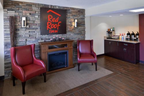 
a red chair sitting in front of a red wall at Red Roof Inn PLUS+ Chicago - Northbrook/Deerfield in Deerfield
