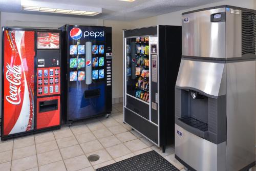two soda machines and a cocacola machine in a store at Super 8 by Wyndham Deerfield - Northbrook in Deerfield