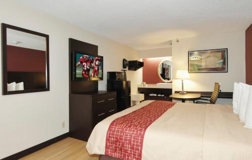 a hotel room with a bed and a desk at Red Roof PLUS Chicago - Hoffman Estates in Hoffman Estates