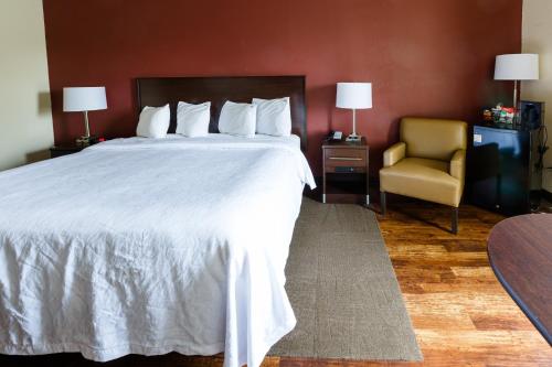 a hotel room with a bed and a chair at Red Roof Inn PLUS+ Danville, KY in Danville