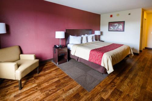 a hotel room with a bed and a chair at Red Roof Inn PLUS+ Danville, KY in Danville
