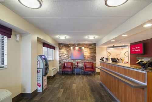 a waiting room at a fast food restaurant with red chairs at Red Roof Inn Madison, WI in Madison