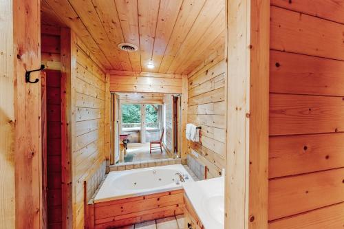 La salle de bains est pourvue d'une baignoire dans un mur en bois. dans l'établissement Creekside Dreams, à Pigeon Forge