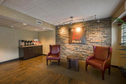 a waiting room with two chairs and a brick wall at Red Roof Inn PLUS+ West Springfield in Springfield