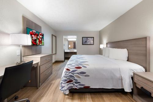 a hotel room with a bed and a desk with a desk at Red Roof Inn Dayton - Moraine/U of Dayton in Dayton
