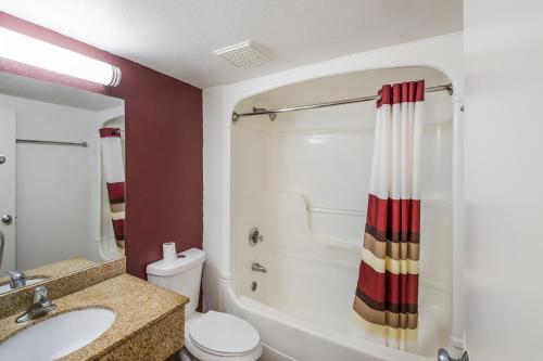 a bathroom with a tub and a sink and a toilet at Red Roof Inn Rochester - Airport in Rochester