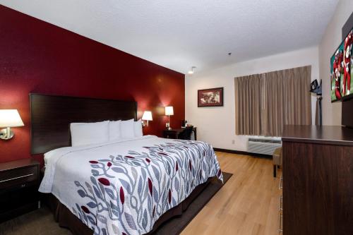 a hotel room with a large bed and red walls at Red Roof Inn & Suites Dover Downtown in Dover