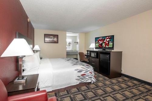 a hotel room with a bed and a flat screen tv at Red Roof Inn Murray in Murray