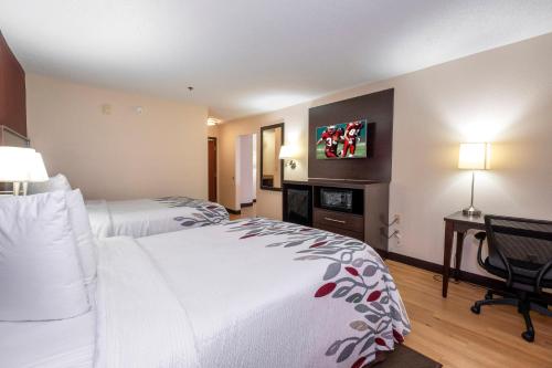 a hotel room with two beds and a desk at Red Roof Inn Knoxville Central – Papermill Road in Knoxville