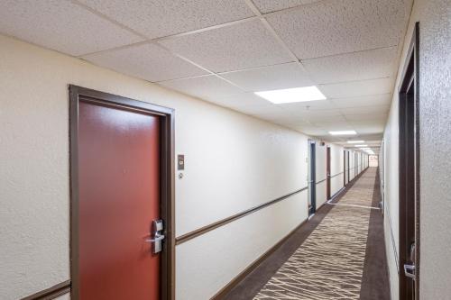 an empty corridor in an office with a red door at Red Roof Inn Knoxville Central – Papermill Road in Knoxville