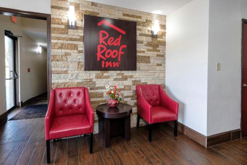 a waiting room with two red chairs and a table at Red Roof Inn Culpeper in Culpeper
