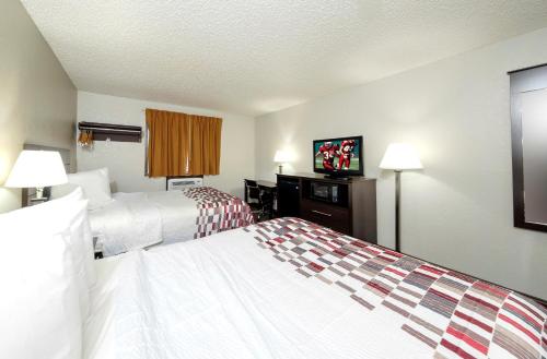 a hotel room with two beds and a flat screen tv at Red Roof Inn Culpeper in Culpeper