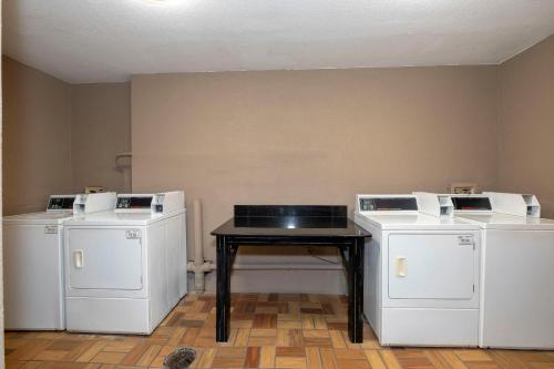 a room with three white washers and a table at Red Roof Inn PLUS+ St. Augustine in Saint Augustine