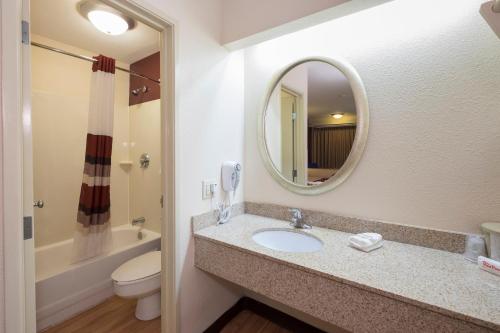 ein Badezimmer mit einem Waschbecken, einem WC und einem Spiegel in der Unterkunft Red Roof Inn Cincinnati - Sharonville in Sharonville