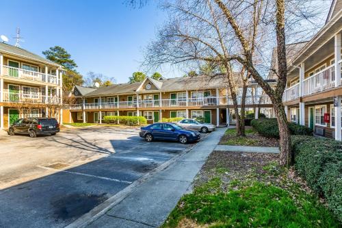 a building with cars parked in a parking lot at HomeTowne Studios by Red Roof Atlanta NE - Downtown Norcross in Norcross