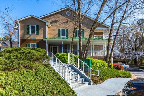 a house with a staircase in front of it at HomeTowne Studios by Red Roof Atlanta NE - Downtown Norcross in Norcross