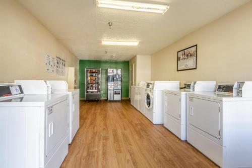 a laundry room with white washers and dryers at HomeTowne Studios by Red Roof Atlanta NE - Downtown Norcross in Norcross