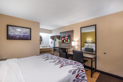 una camera d'albergo con letto e scrivania di Red Roof Inn Kalamazoo West - Western Michigan U a Kalamazoo