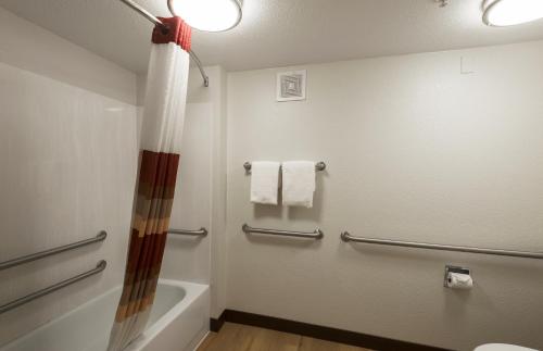 a bathroom with a shower and a tub and a toilet at Red Roof Inn Dayton North Airport in Dayton