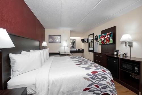 Habitación de hotel con cama grande con almohadas blancas en Red Roof Inn Champaign - University, en Champaign