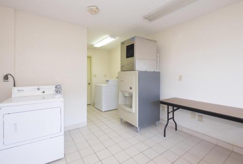 a kitchen with a refrigerator and a table in it at Red Roof Inn Columbus Northeast Westerville in Westerville