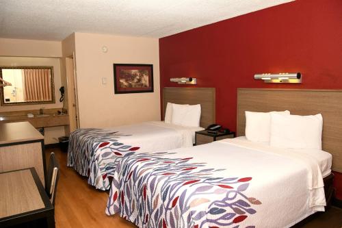 2 camas en una habitación de hotel con paredes rojas en Red Roof Inn Richmond South, en Richmond