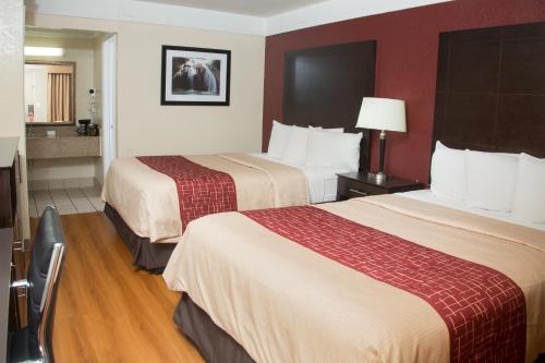 um quarto de hotel com duas camas e uma cozinha em Red Roof Inn Ardmore em Ardmore