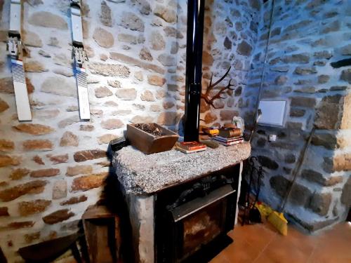 a stone fireplace in a room with a stone wall at casa de Castelo Mendo in Castelo Mendo