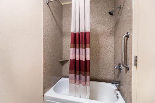 a bath tub with a red and white shower curtain at Red Roof Inn Murfreesboro in Murfreesboro