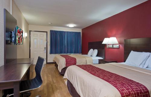Habitación de hotel con 2 camas y escritorio en Red Roof Inn Corpus Christi South, en Corpus Christi