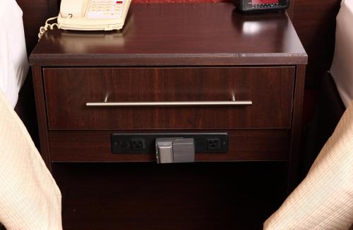 a wooden nightstand with a phone on top of it at Red Roof Inn Merrillville in Merrillville