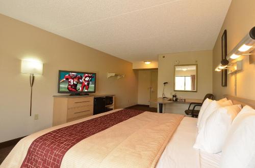 a hotel room with a bed and a flat screen tv at Red Roof Inn San Antonio Airport in San Antonio