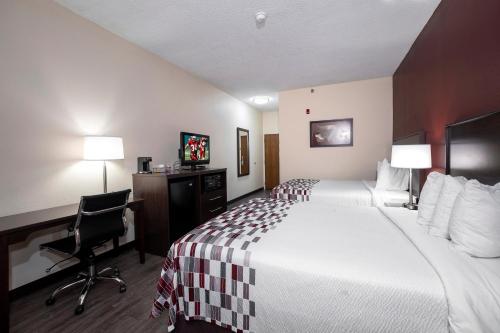 a hotel room with a bed and a desk with a computer at Red Roof Inn Prattville in Prattville