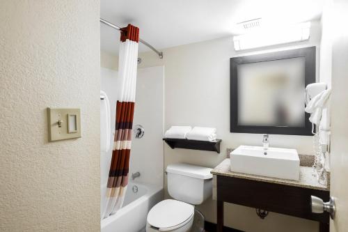 La salle de bains est pourvue de toilettes, d'un lavabo et d'une télévision. dans l'établissement Red Roof Inn PLUS+ San Antonio Downtown - Riverwalk, à San Antonio