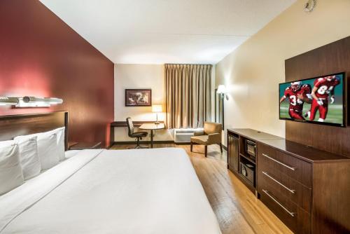 サンアントニオにあるRed Roof Inn PLUS+ San Antonio Downtown - Riverwalkのベッド1台、薄型テレビが備わるホテルルームです。