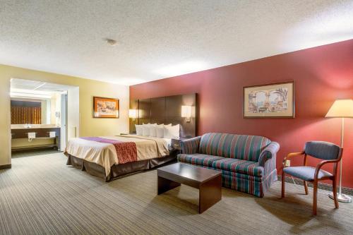 a hotel room with a bed and a couch at Red Roof Inn Vincennes in Vincennes