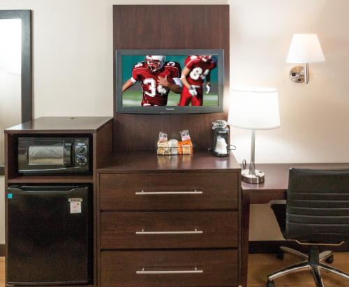 a hotel room with a desk with a tv and a football at Red Roof Inn PLUS+ Washington DC Rockville in Rockville