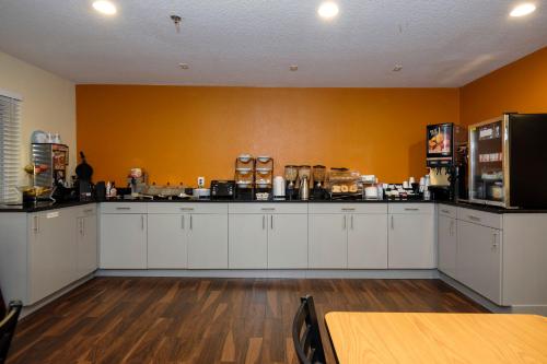 a kitchen with white cabinets and a yellow wall at Red Roof Inn Osage Beach - Lake of the Ozarks in Osage Beach